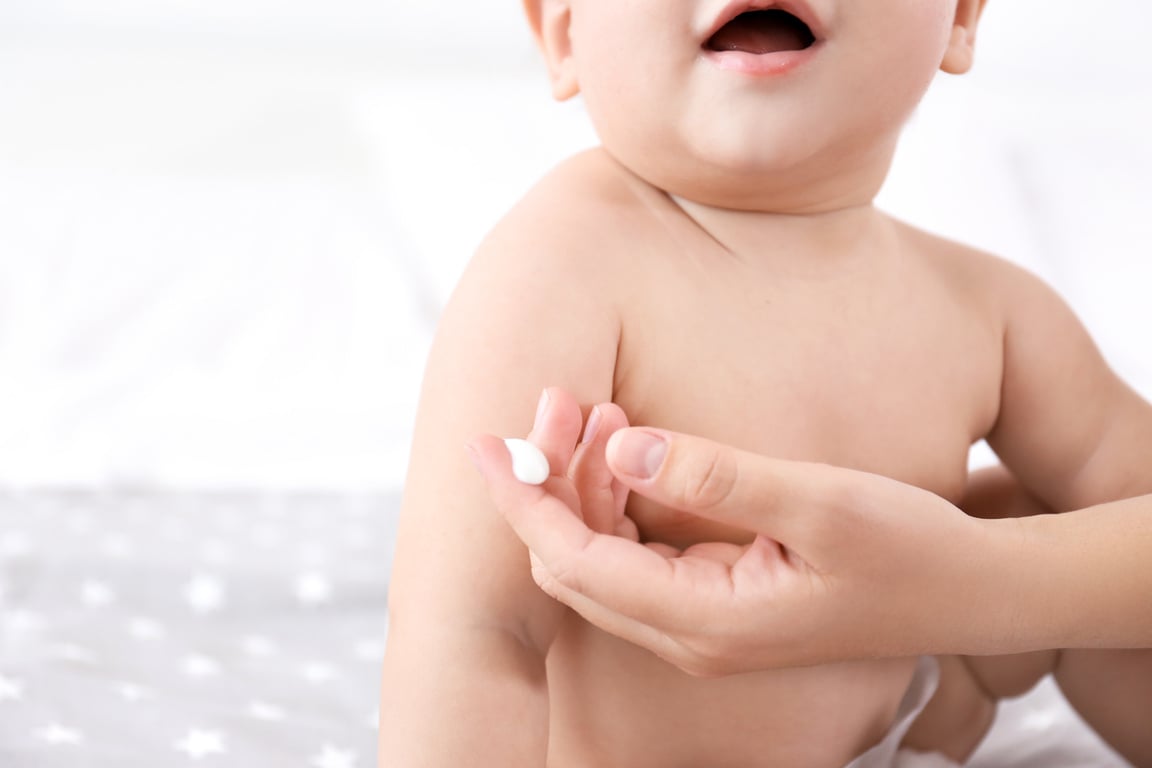 Woman Applying Body Cream on Her Baby